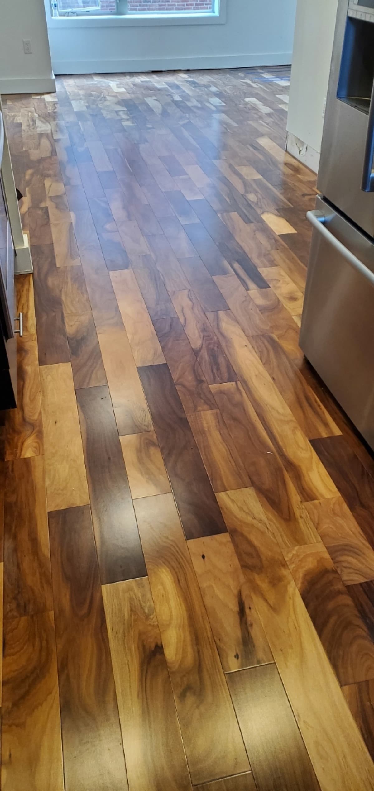 Glossy exotic hardwood flooring in a residential kitchen — installed by Threshing Floors