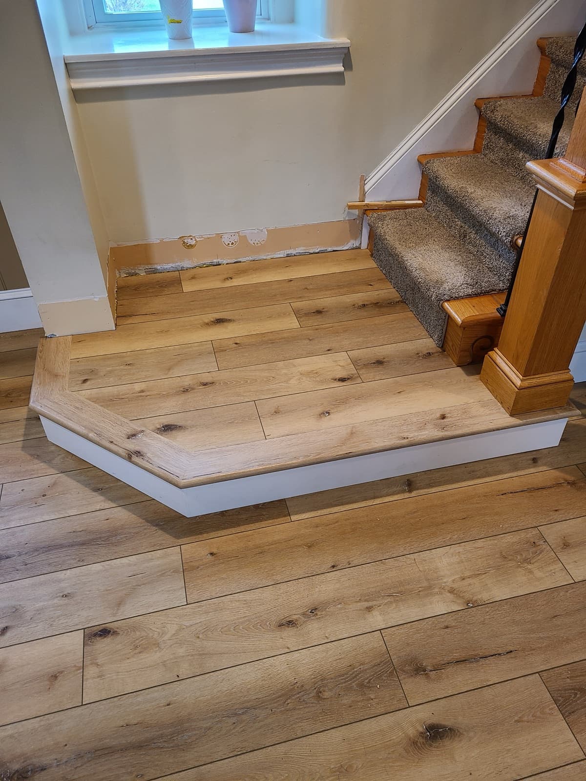 Wide-plank oak hardwood flooring at a stair landing — installed by Threshing Floors