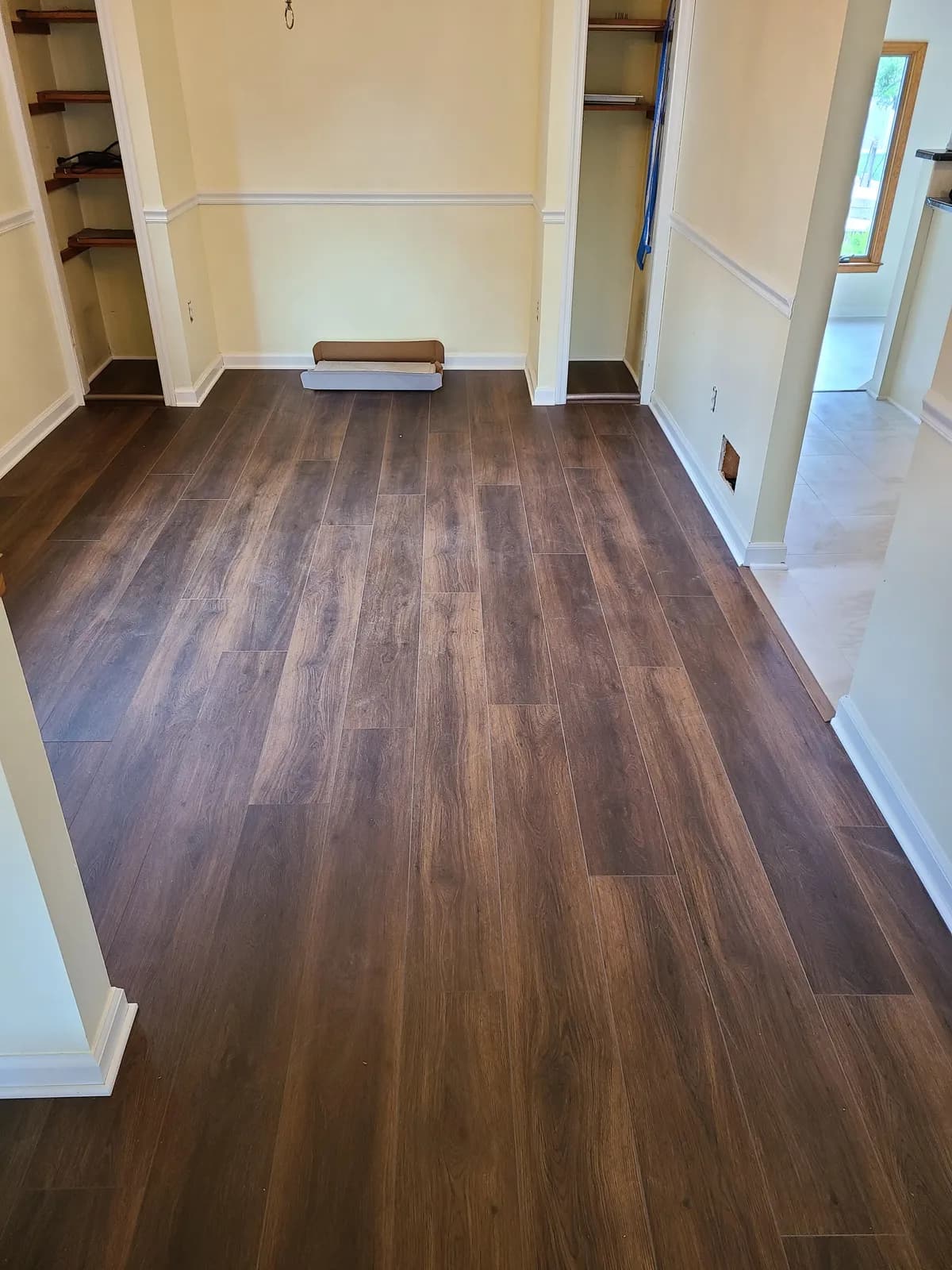 Brown oak-look LVP plank flooring in a sitting room with built-in shelving — installed by Threshing Floors