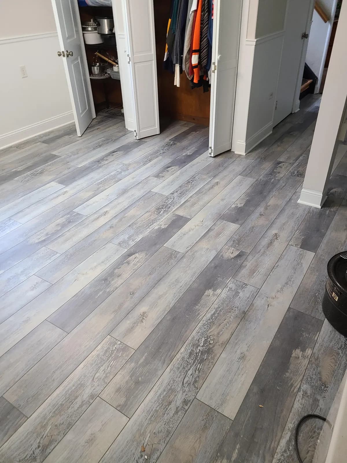 Gray driftwood LVP plank flooring in a bedroom — installed by Threshing Floors