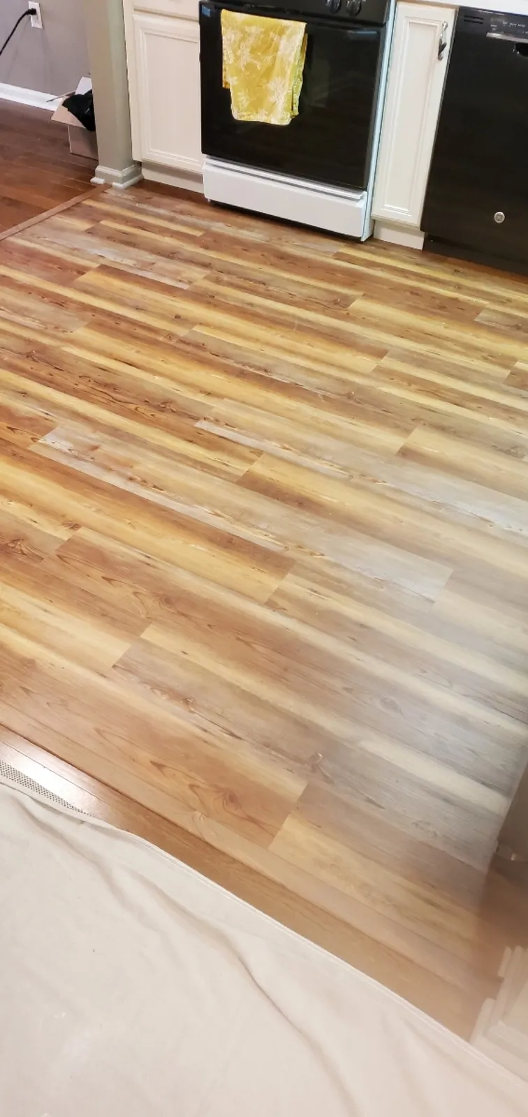 Wood-look LVP flooring install detail in a residential kitchen — installed by Threshing Floors