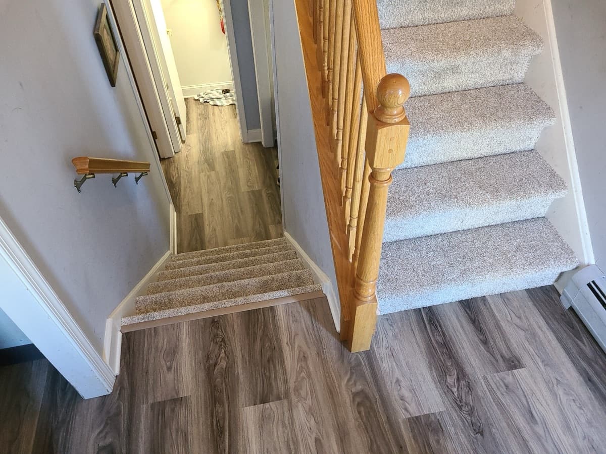 LVP plank flooring on a stair landing and hallway — installed by Threshing Floors