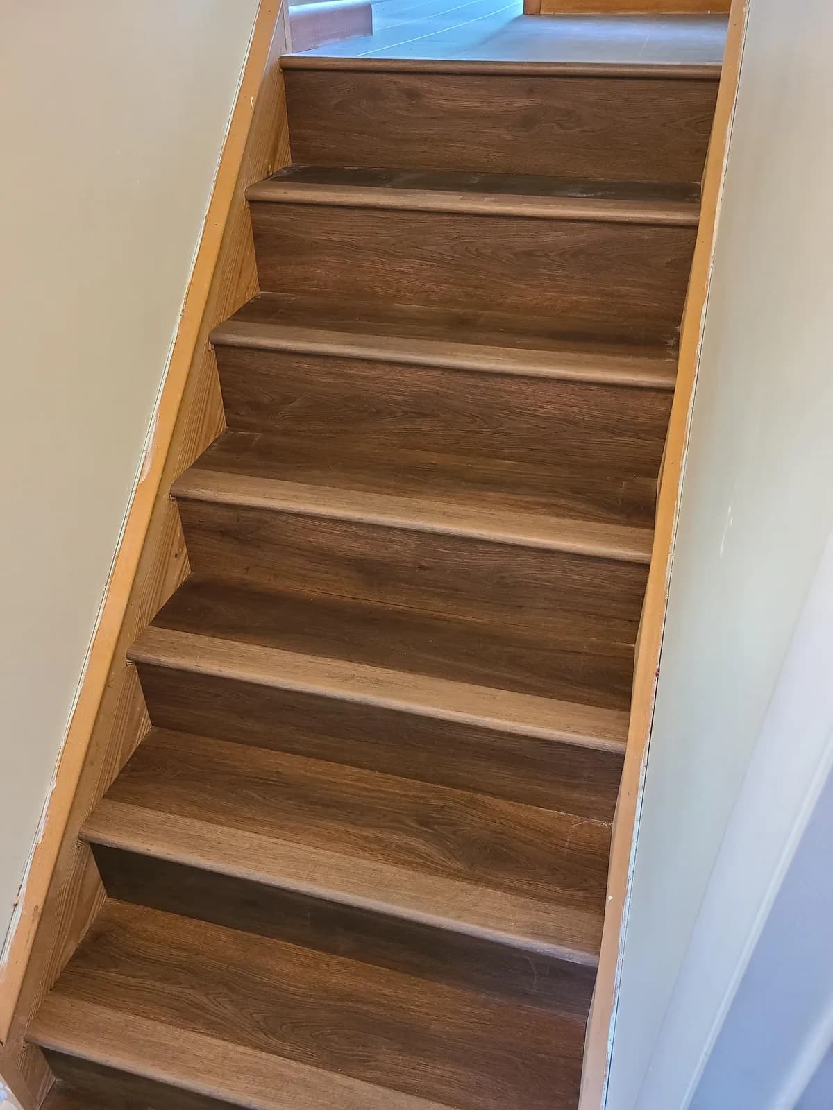 Brown wood-look LVP stair treads and risers, full staircase detail — installed by Threshing Floors