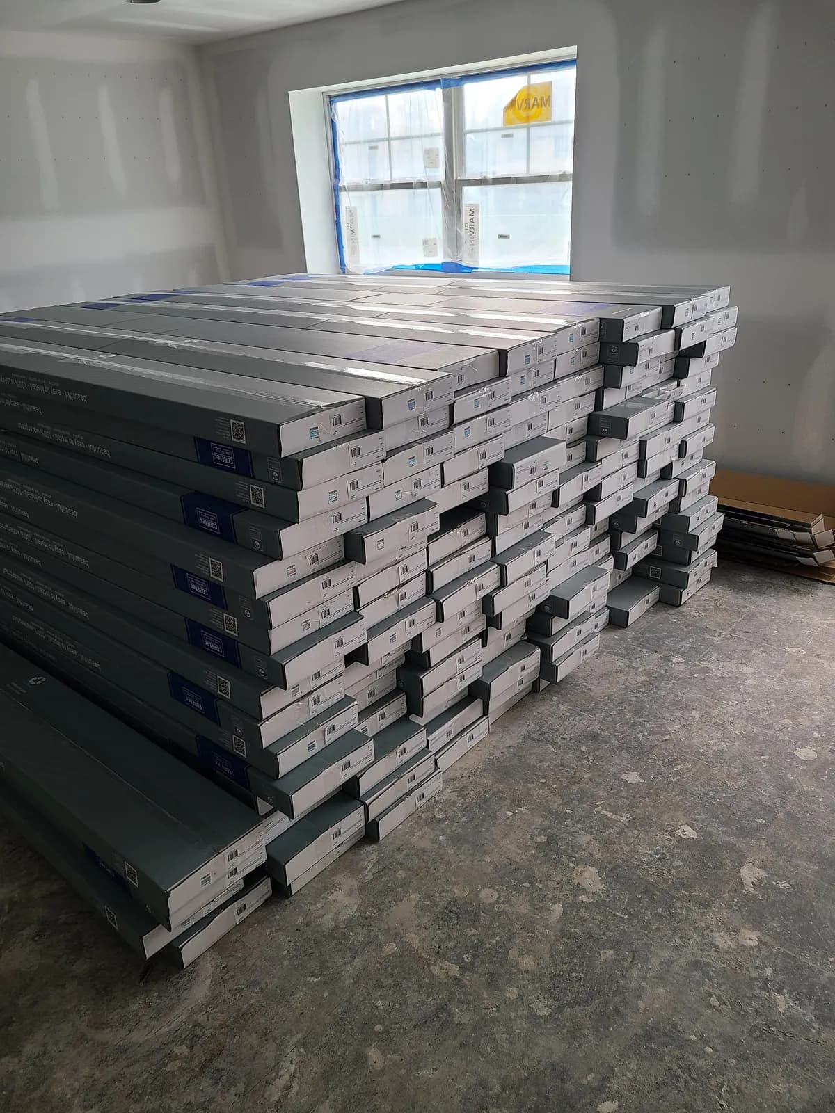 Boxes of luxury vinyl plank flooring acclimating on site before installation