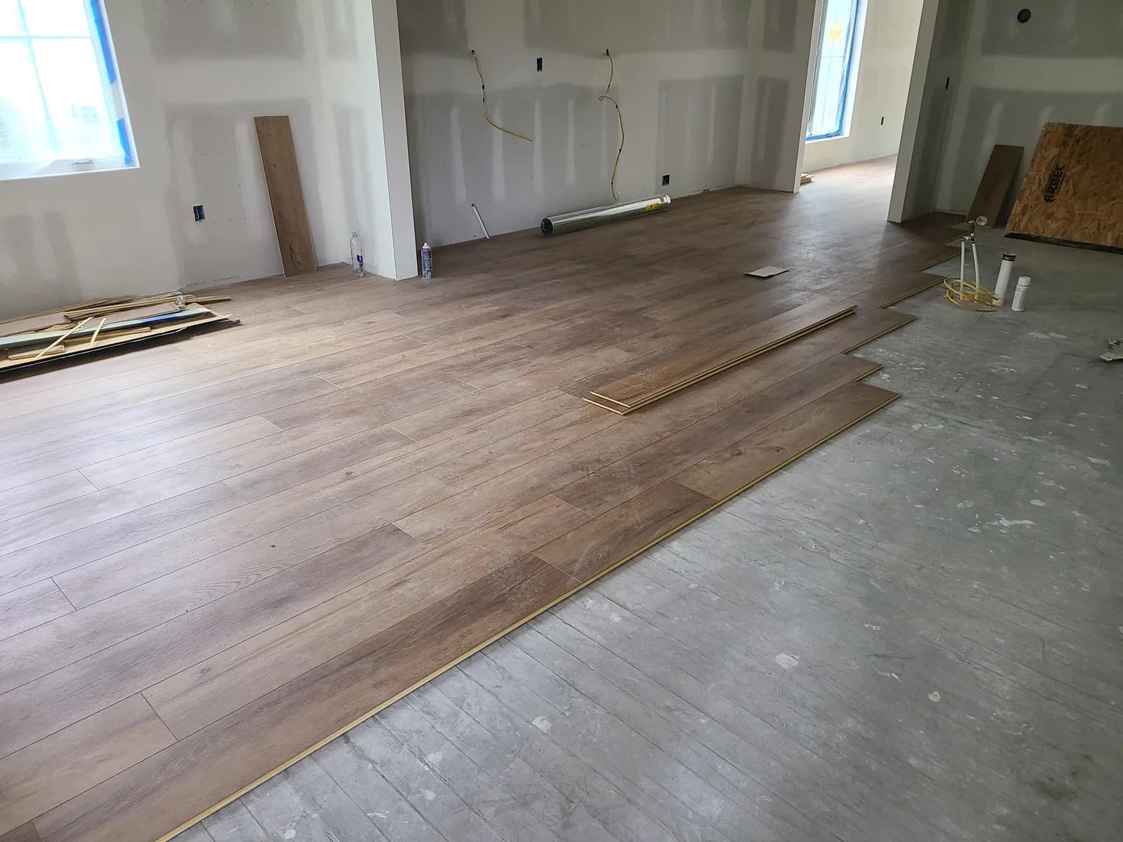 LVP installation in progress showing the clean line between finished floor and bare subfloor