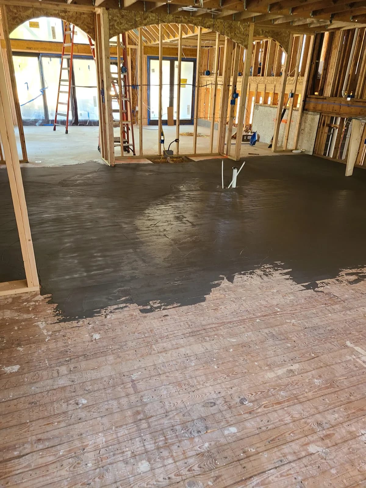 Threshing Floors crew working on a prepped subfloor in a new-construction home before LVP installation