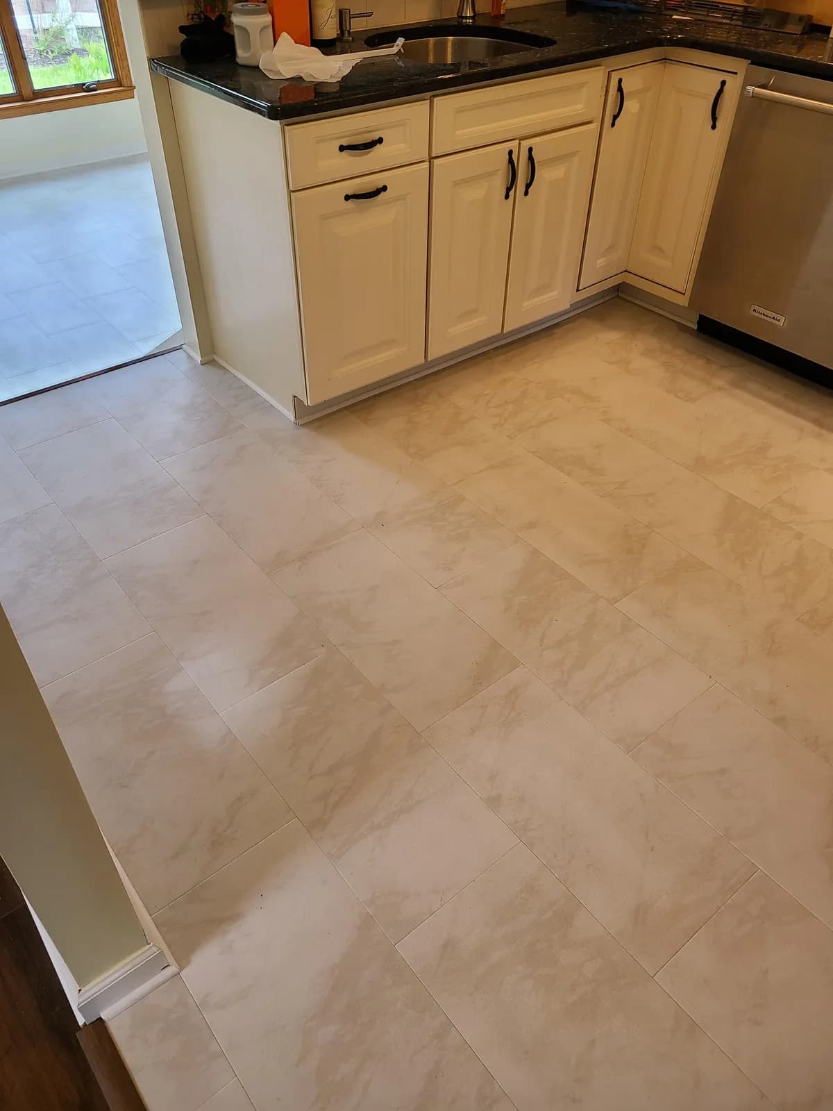 Cream marble-look porcelain tile flooring in a kitchen, installed by Threshing Floors