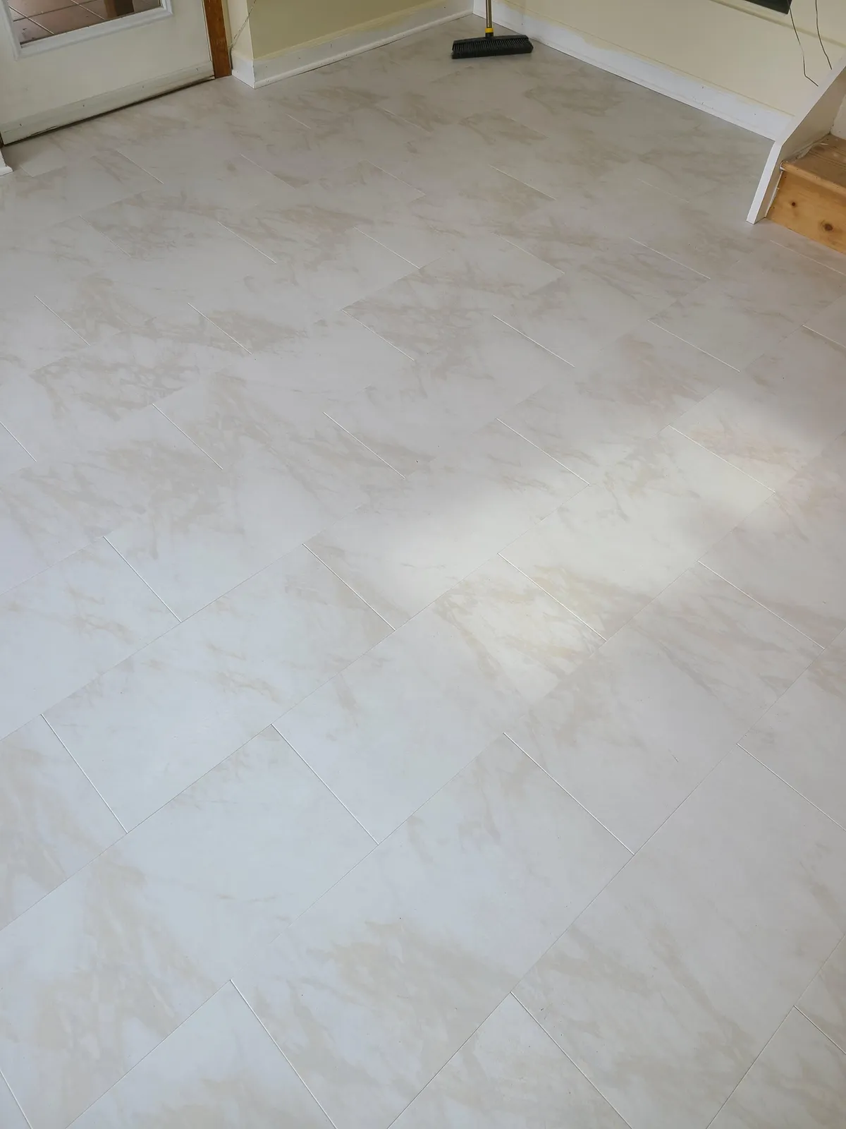 White marble-look porcelain tile flooring in a bright sunroom — installed by Threshing Floors