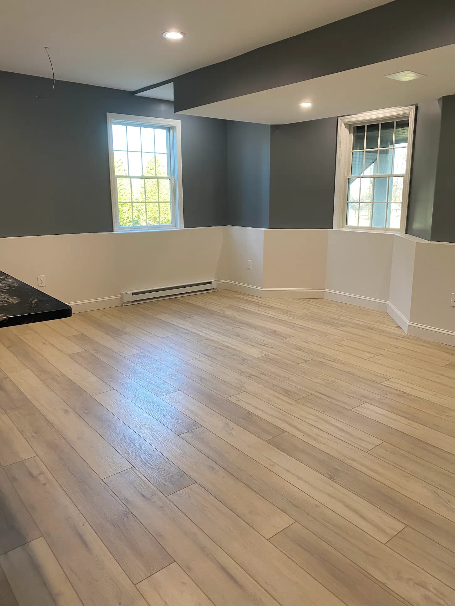 Light blonde LVP plank flooring in a bright residential living room — installed by Threshing Floors